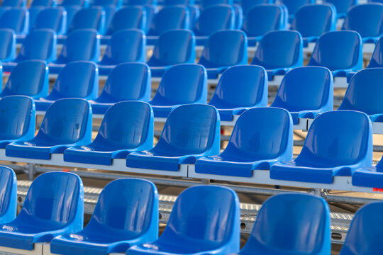 Vibrant rows of empty blue seats await eager spectators at a lively sports event during a sunny day