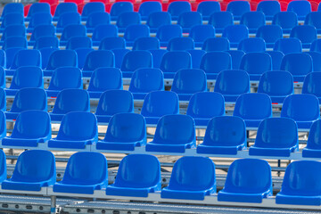 Fototapeta premium Vibrant blue and red seating arrangement at an outdoor event during a sunny day