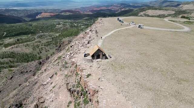 Drone circles the summit building at Brian Head Peak, revealing Cedar Breaks, distant mountains, alpine meadows, forests, and sweeping southern Utah scenery.
