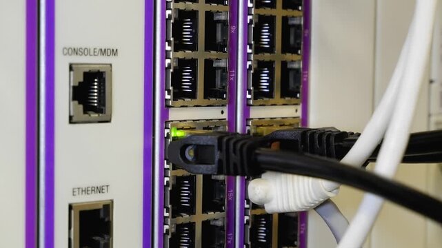 Technician Plugging Ethernet Cable Into Network Switch 4K