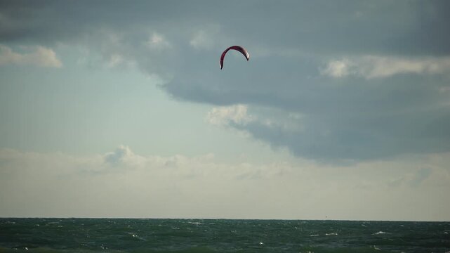 Kiteboarding, Ocean, Clouds - Kitesurfer riding a kiteboard on a windy day.