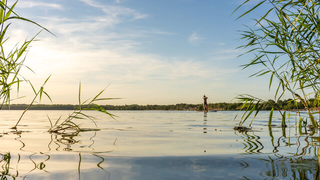 SUP fahren bei einem wundersch&ouml;nen Sonnenuntergang am Cospudener See in Leipzig im Sommer