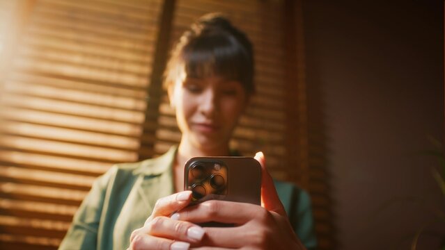 Young woman looking at her smartphone screen with a thoughtful expression