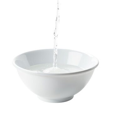 A white bowl filled with running water from the faucet
