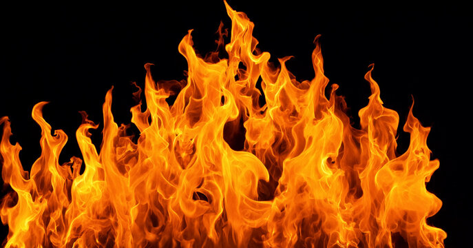 Intense orange fire flames dancing fiercely against dark black background for dramatic effect