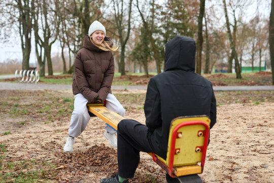 A happy girl and a boy on the playground. The concept of carefree childhood, fun in the fresh air.