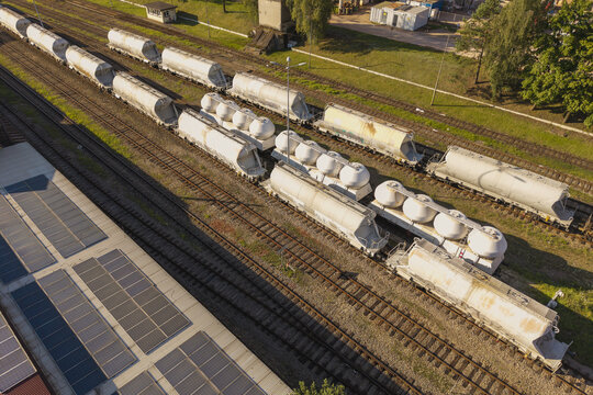 Aerial view of a freight train with white tanker cars on railway tracks in Poland.