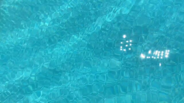 Clear blue water in a swimming pool with gentle ripples creates a calming pattern. Sunlight reflects on the surface, casting a peaceful, serene ambiance