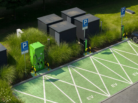 Aerial view of an EV car charger station with green parking spaces and modern charging equipment in a parking lot in Krakow, Lesser Poland Voivode, Poland.