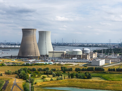Aerial view of the Doel Nuclear Power Plant with cooling towers along the Scheldt river, surrounded by fields and industrial infrastructure in Beveren-Kruibeke-Zwijndrecht, Vlaanderen, Belgium.