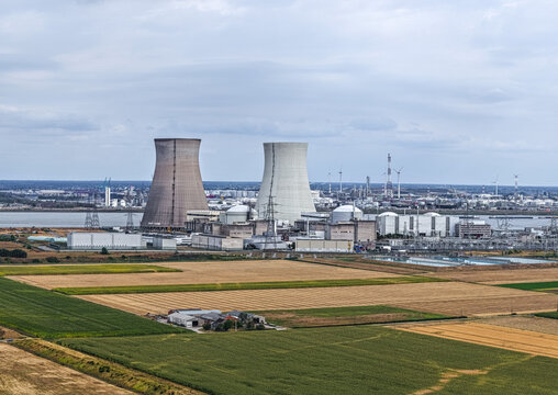 Aerial view of the Doel Nuclear Power Station with its cooling towers, surrounded by agricultural fields and industrial infrastructure in Beveren, Vlaanderen, Belgium.