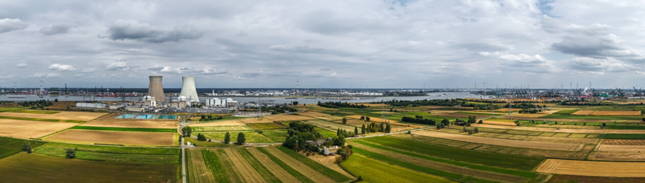 Aerial view of the Doel Nuclear Power Station with its cooling towers along the Scheldt river, surrounded by agricultural fields, Beveren, Vlaanderen, Belgium.