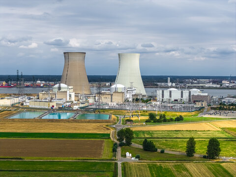 Aerial view of the Doel Nuclear Power Plant with its iconic cooling towers, industrial facilities, and surrounding agricultural fields in Beveren, Vlaanderen, Belgium.