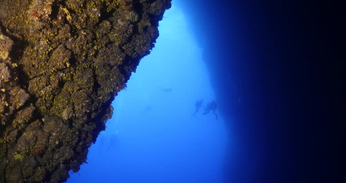 scuba divers are starting a cave dive underwater