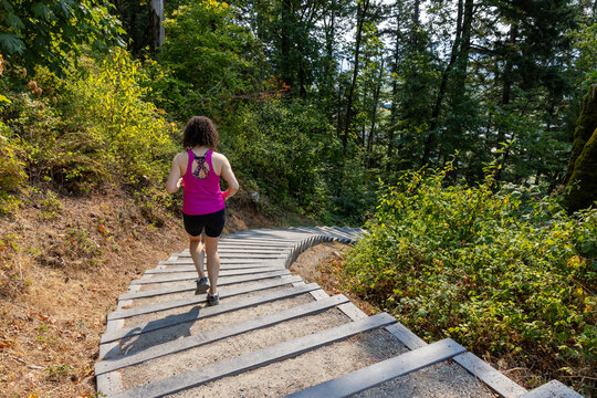 Woman Running Down Forest Stairs at Little Mountain Stairs, Chilliwack, BC Canada for Outdoor Fitness