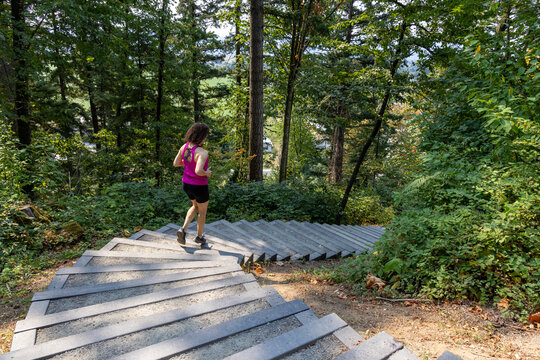 Woman Runner Descending Forest Stairs at Little Mountain Stairs in Chilliwack BC Canada for Fitness