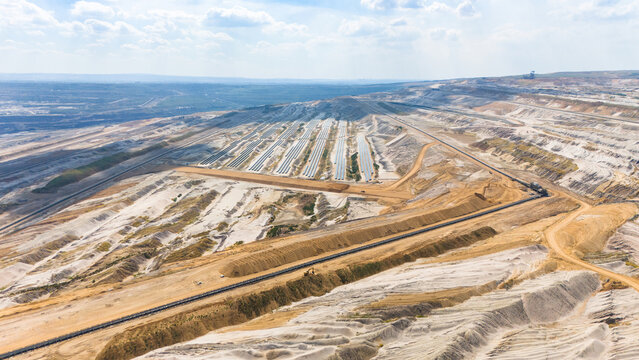 Aerial view of Hambach open pit mine showing lignite mining operations and solar photovoltaic modules as a transition to renewable energy in Elsdorf, North Rhine-Westphalia, Germany.