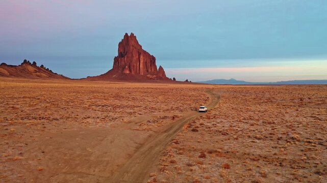 Car Driving Along Desert Road Toward Shiprock in New Mexico