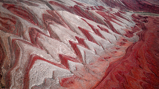 Aerial view of the striking chevron folds and zig-zag geological rock formations in the desert landscape of Moab, Utah, United States.