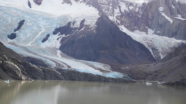 Majestic panoramic view of the Piedras Blancas Glacier in Los Glaciares National Park, Patagonia, Argentina, with its blue ice flowing into a grey glacial lake and snowy peaks