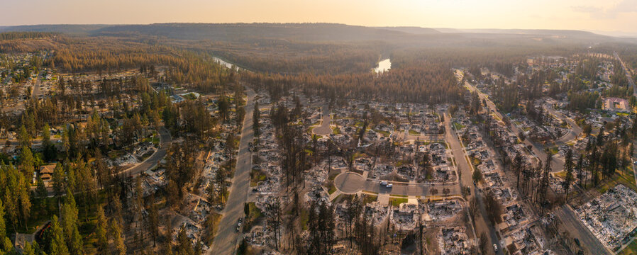 Aerial view of Spokane wildfire damage showing destroyed residential homes, charred trees, and a river in the background in Spokane, Washington, United States.