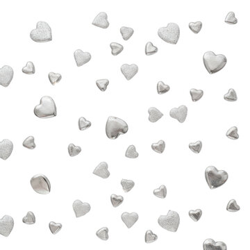Small polished silver hearts and fine metallic glitter scattered on a bright white surface, top-down view with shimmering light concept of festive elegance