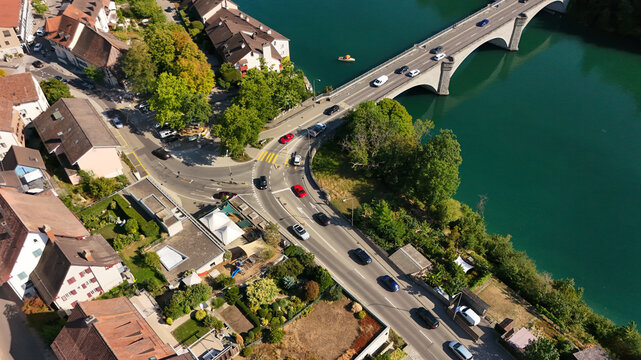Aerial view of the historic town of Eglisau with its bridge crossing the Rhine river, surrounded by lush greenery and traditional buildings in Eglisau, Zurich, Switzerland.