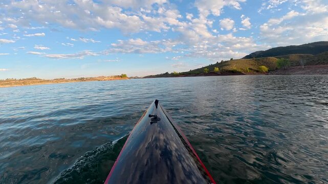 Immersive POV kayaking across Horsetooth Reservoir in Fort Collins, Colorado - summer scenery as a carbon fiber kayak glides on a calm water, surrounded by the scenic foothills of the Rocky Mountains 