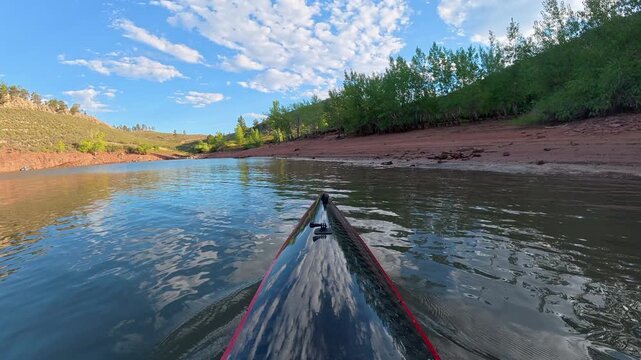Immersive POV kayaking across Horsetooth Reservoir in Fort Collins, Colorado - summer scenery as a carbon fiber kayak glides on a calm water, surrounded by the scenic foothills of the Rocky Mountains 