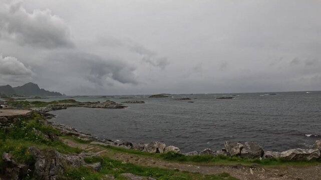 Ground level ultra wide view of rocky coastline, small islands, and stormy ocean in Andenes Norway