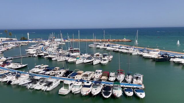 Barco, velero y lancha en puerto deportivo mar&iacute;timo club n&aacute;utico marina nautical club costa en vacaciones de verano d&aacute;rsena, embarcadero y pantal&aacute;n desde mirador