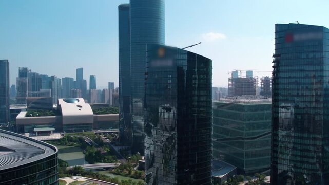 A daytime view of a modern urban skyline featuring sleek glass skyscrapers and ongoing construction in a metropolitan district.