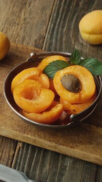 Vertical video. Fresh apricots on wooden table. Summer seasonal fruits.