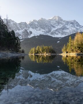 Island in front of mountains, golden light, coniferous forest, Eibsee lake, Zugspitze, Germany