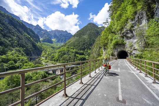 Cyclists with panniers on a cycle path with tunnel, cycle path along the old Pontebba railway line in Eisental, mountain landscape of the Julian Alps, Alpe-Adriatic cycle path, bike packing, Friuli-Venezia Giulia, Italy