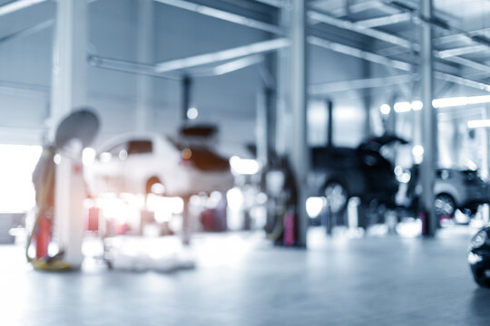 Cars undergoing maintenance in auto service bay interior, blur background