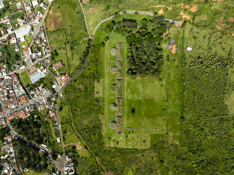Aerial view of the Yacatas Tzintzuntzan archaeological site with its five circular stone structures surrounded by lush green lawns and forest in Tzintzuntzan, Michoacan, Mexico.