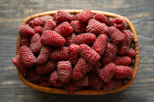 Fresh organic raspberries on wooden table background, food blogging, healthy eating concepts, and seasonal summer harvest themes. Small Farm food	