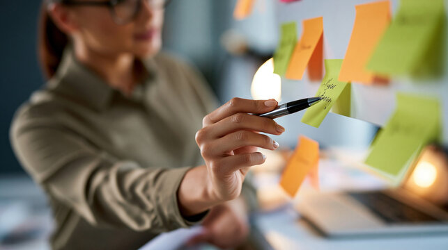 Faceless businesswoman arranging colorful notes on a project planning board, hands and workspace in focus, business strategy, project management, productivity, corporate planning,