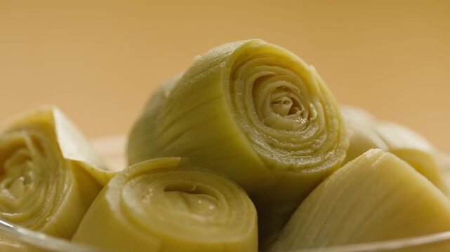 Marinated artichokes in a glass jar isolated on a white background. Mediterranean preserved vegetables, gourmet appetizer, healthy organic food, ready to eat, close-up.
