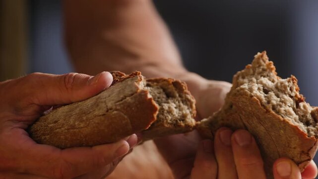 Bread rye loaf cut with knife by hand, fresh homemade sourdough on wooden board, close-up macro shot