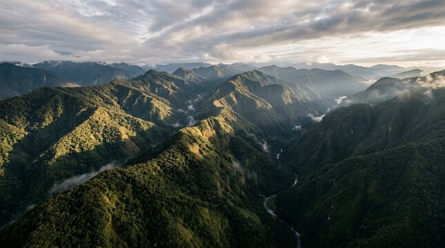 Breathtaking Aerial View of Majestic Green Mountain Ridges and Deep Valleys Under a Dramatic Cloudy Sunrise Sky