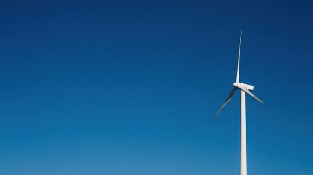 Closeup wind turbine nacelle and blades against clear blue sky for clean energy banner background and industrial design