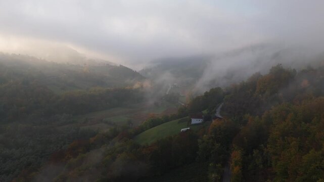 A drone camera flies over autumn mountains early in the morning at dawn