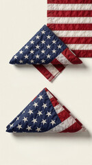 Obraz premium Two folded american flags rest on light surface. Stars and stripes display patriotic symbol. Clean composition for national holidays and events.
