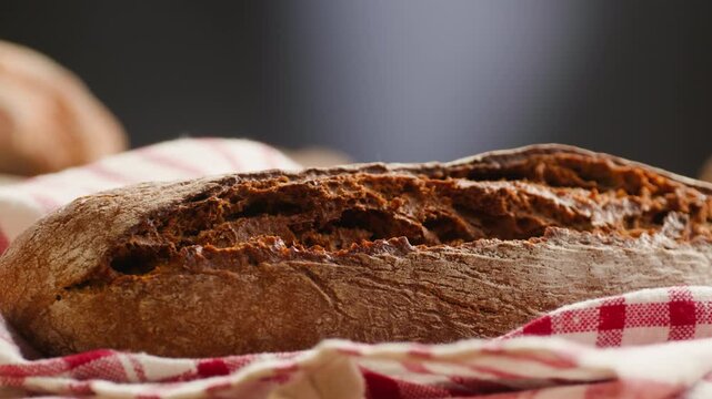 Bread multigrain loaf held in hands, whole wheat seeded crust with millet and seeds, close-up macro shot