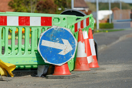 Keep right sign with traffic cones and green barrier close up detail