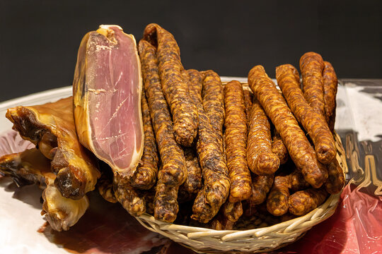 Fresh organic dry pork ham and sausages meat inside rattan basket