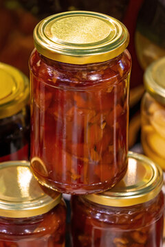 Homemade organic fruit jam inside glass jar in home pantry interior
