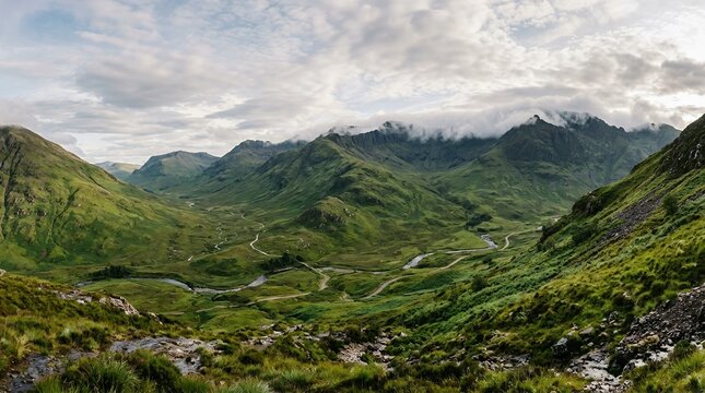Majestic Green Highland Mountains with Winding River Valley and Misty Cloud Covered Peaks at Sunrise Landscape